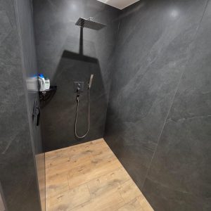 Moderne Dusche mit schwarzen Fliesen