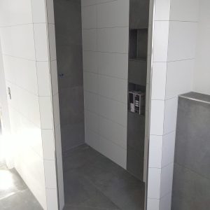 Dusche mit weiß-grauen Fliesen in moderner Optik